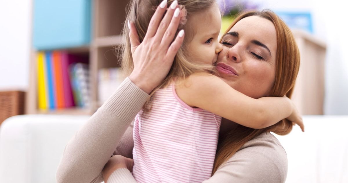 Une assistante maternelle câline un enfant